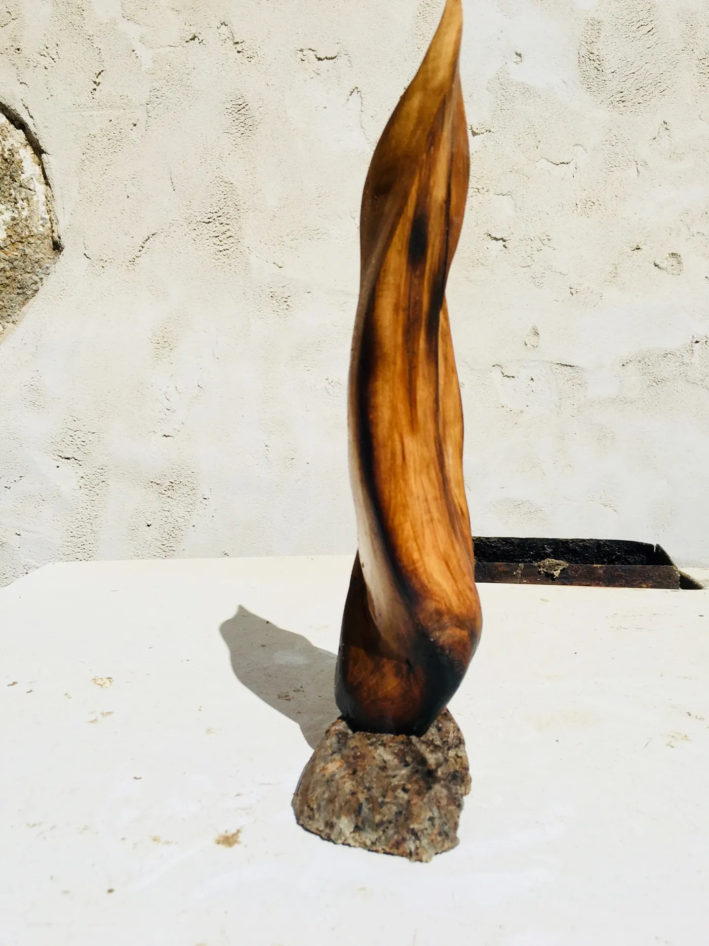 Slender flame on a stone base